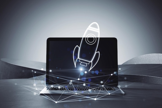 A laptop with a holographic rocket projection on a dark background illustrating a concept of innovation and technology