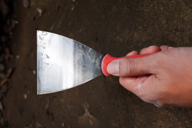 Foto a wall paint scraper is being held against the floor