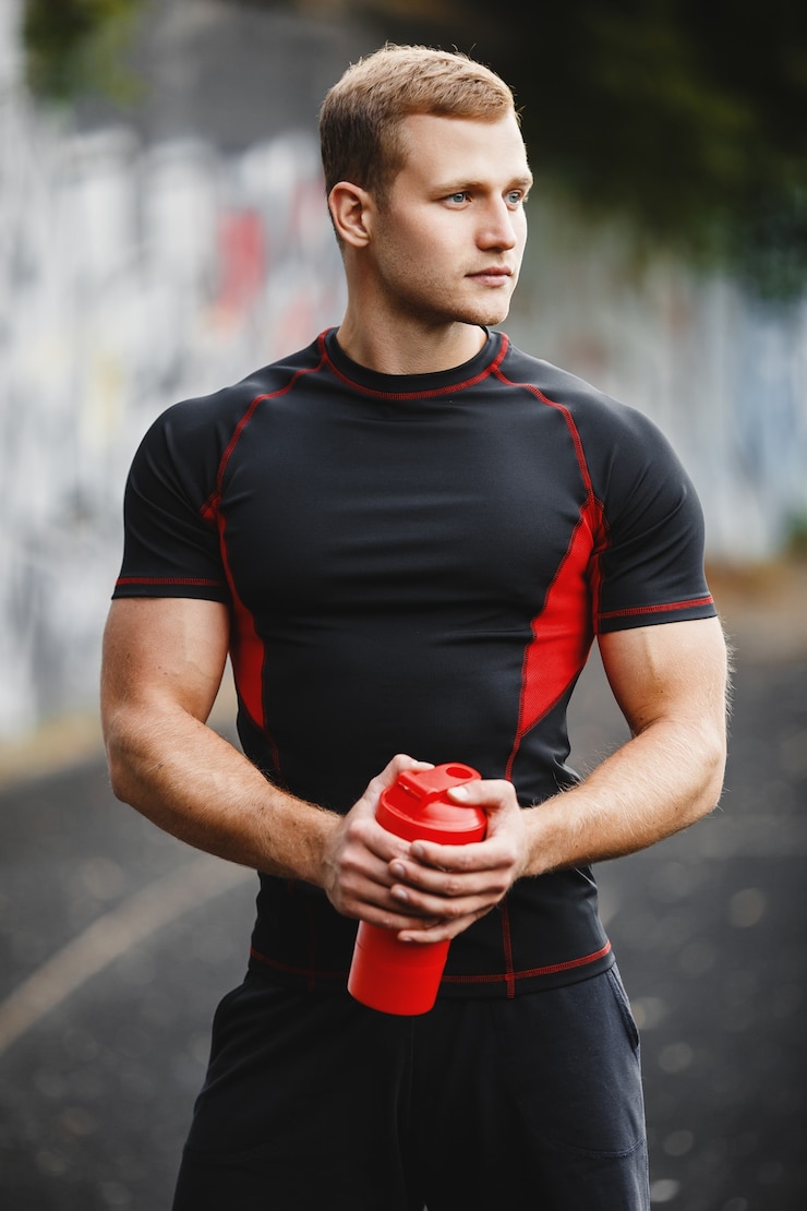 Foto a young athletic man in a stadium with a shaker in his hands the guy on the evening jog