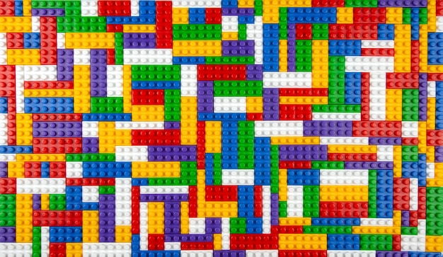 Abstract background texture of colored constructor blocks Background of colorful plastic part of constructor Pile of colored toy bricks