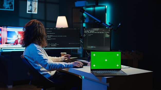 Admin using green screen laptop to implement security measures