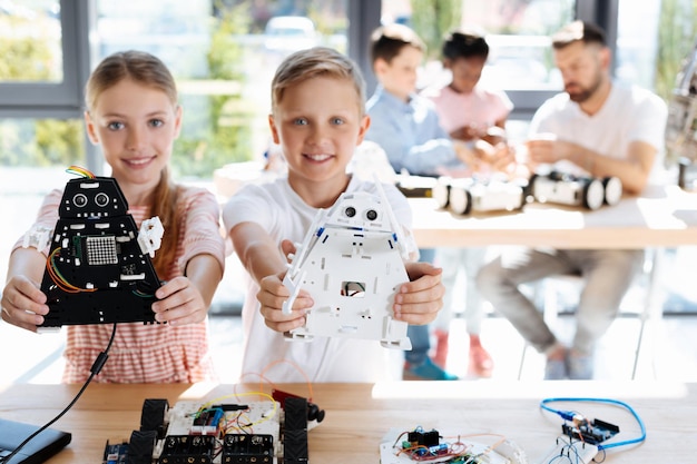 adorable pre-teen kids inspecting robotic vehicle workshop
