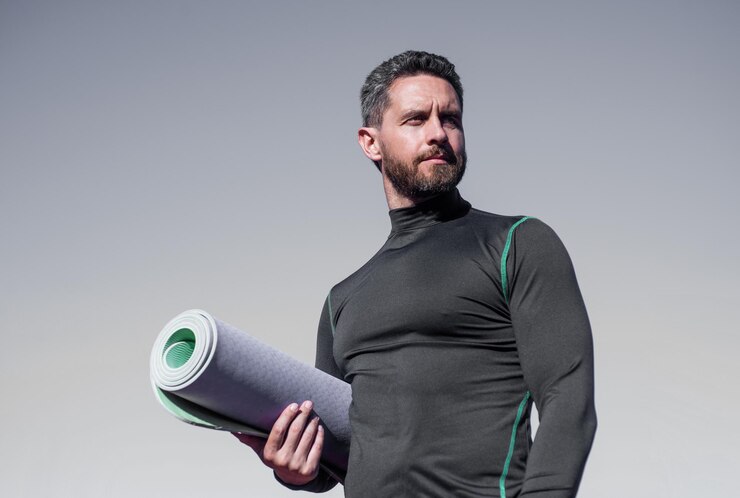 Foto athletic muscular man hold yoga mat pilates