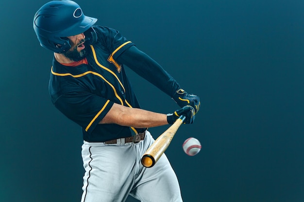 Baseball player with bat taking a swing on grand arena ballplayer on dark background in action