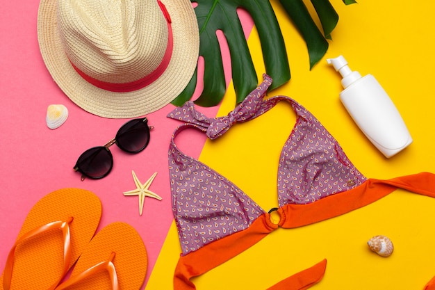 Beachwear and accessories on a pink and yellow background