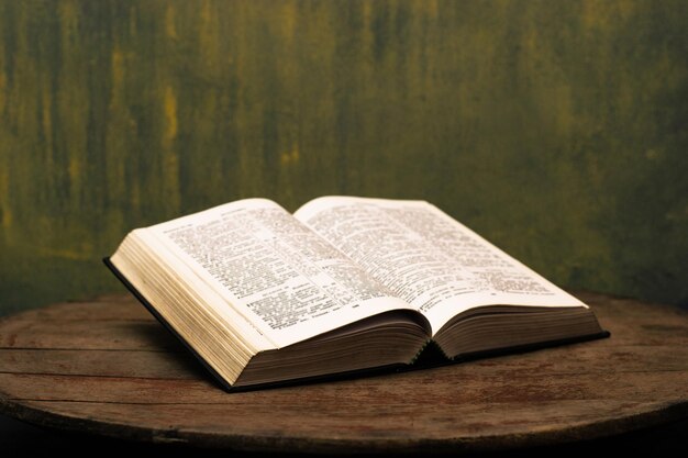 Bible on a old round wooden table Beautiful gold backgroundReligion concept