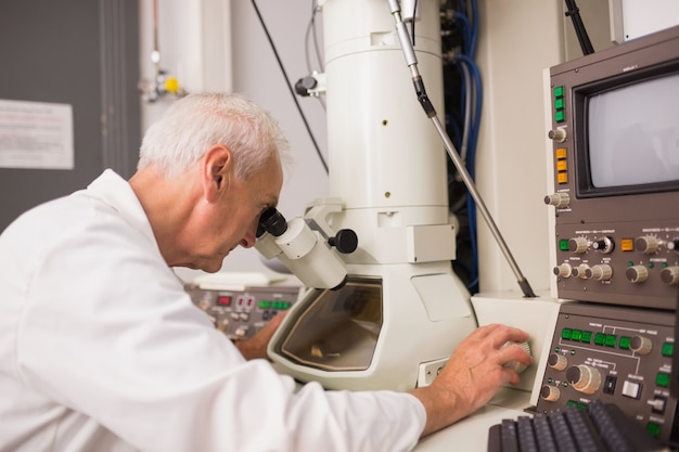 biochemist using large microscope and computer