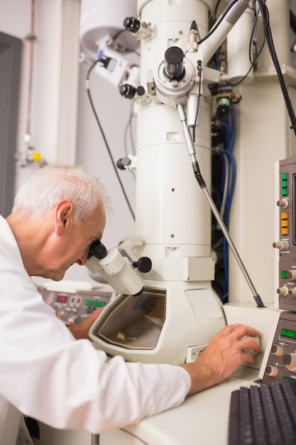 biochemist using large microscope and computer