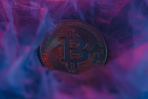 Bitcoin-mynt under neon på teksturert overflate Foto for presentasjon og nyheter