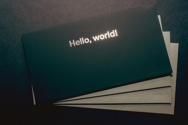Black envelope on top, on gray envelopes on the bottom, on a dark flat background, luxury corporate identity and corporate identity design for layouts with the inscription hello world