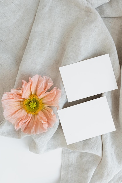 Blank paper sheet cards with mockup copy space poppy flower on crumpled fabric Aesthetic wedding invitation template Flat lay top view
