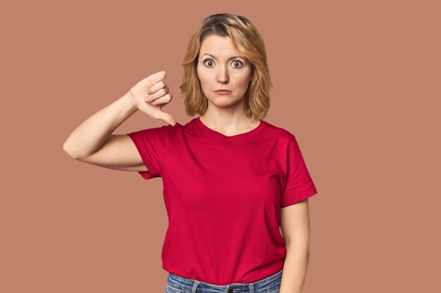 Blonde middleaged Caucasian woman showing a dislike gesture thumbs down Disagreement concept