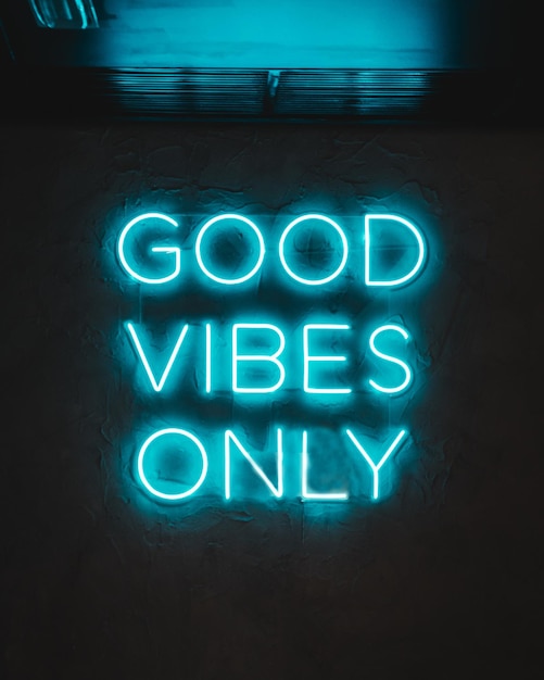 Blue neon glowing light on a wall with words ''Good Vibes Only''
