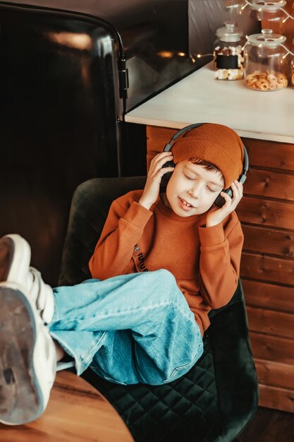 Boy in headphones listening to music with his feet on the table