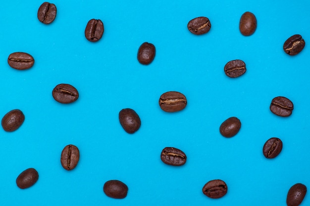 Brown coffee beans on blue background
