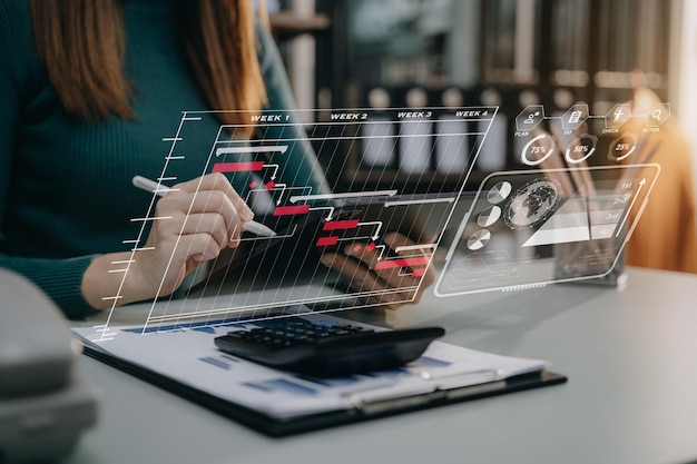 business woman hand project manager working and update tasks and gantt chart scheduling virtual diagram with tablet and laptop in office