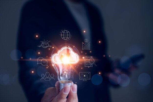 Businessman hand holding creative light bulb with icons global Internet connection on plan strategy big data Business connection application technology and digital marketing Financial and banking