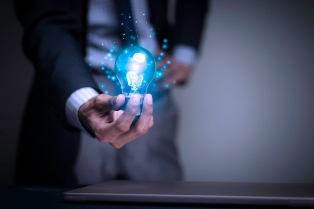 Businessman holding a light bulb creates new ideas Innovation Brainstorming Solutions And inspiration Imagination Creativity Problem solving Solution removing obstacles to success in business