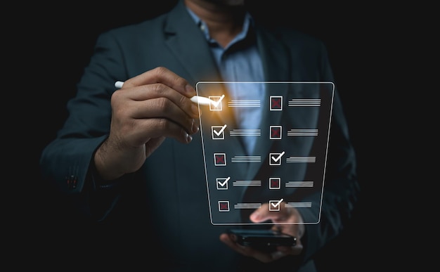 Businessman point pen on virtual screen filling out online survey forms managing documents checklists clipboards Enterprise business technologies including document management systems DMS