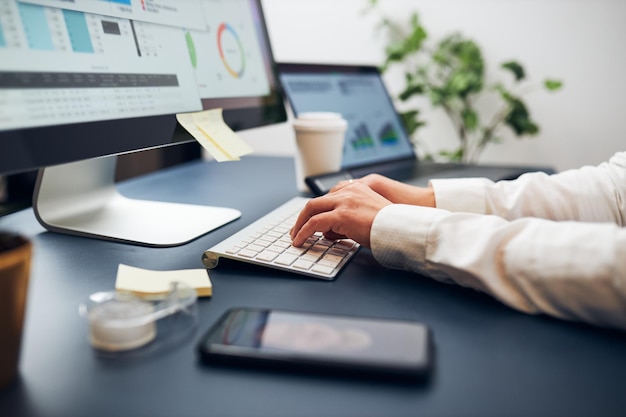 Businesswoman having video chat on mobile phone businesswoman working with chart typing on keyboard