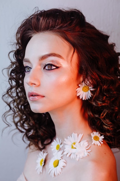 close-up of beautiful young woman wearing flowers and make-up