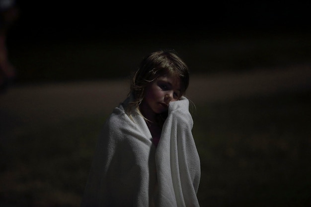 Close-up of girl wrapped in a towel at night