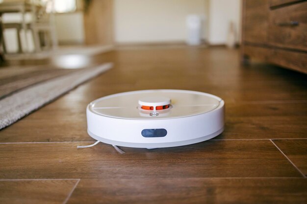 Close up of smart gadget working chore and vacuuming floor at home