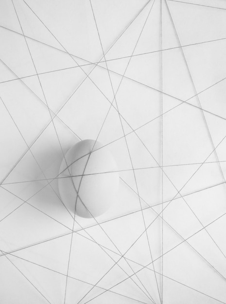 close-up of tangled strings with egg on white table
