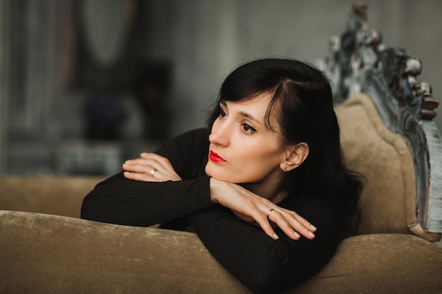 Close-up of thoughtful woman relaxing on sofa at home