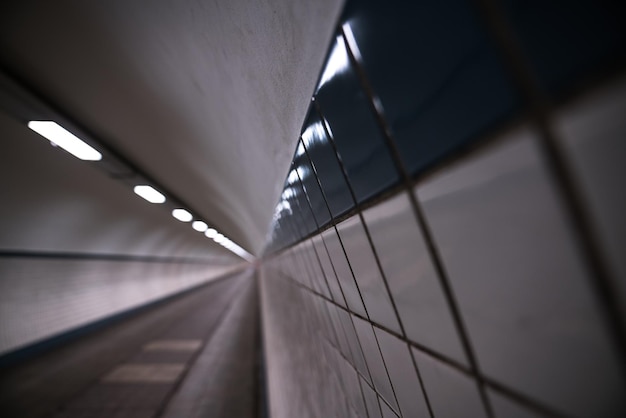 Close-up of tiled wall in illuminated tunnel