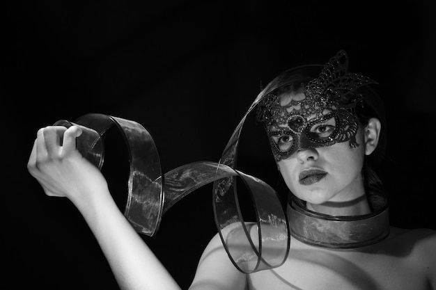 Close-up of woman wearing mask against black background