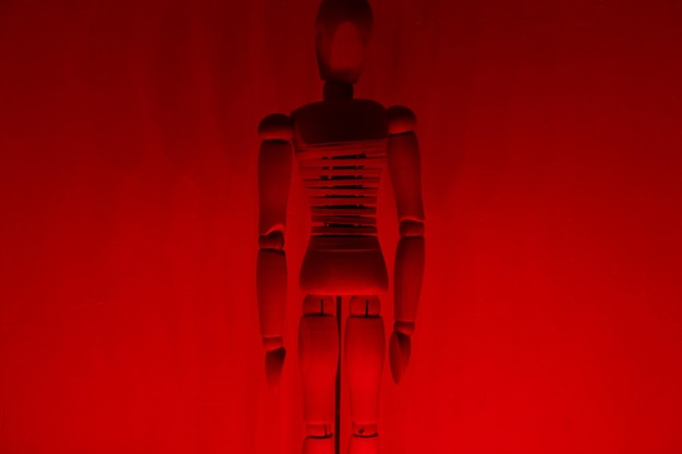 Close-up of wooden figurine against red wall