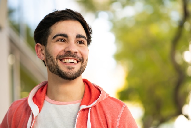 Close-up of young man smiling while standing outdoors at the street