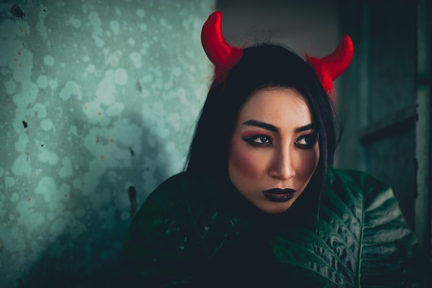 Close-up of young woman wearing spooky make-up and horned headband