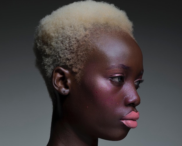 Close-up of young woman with blond hair against gray background