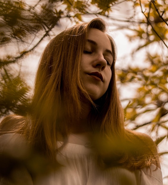 Close-up of young woman with eyes closed standing outdoors