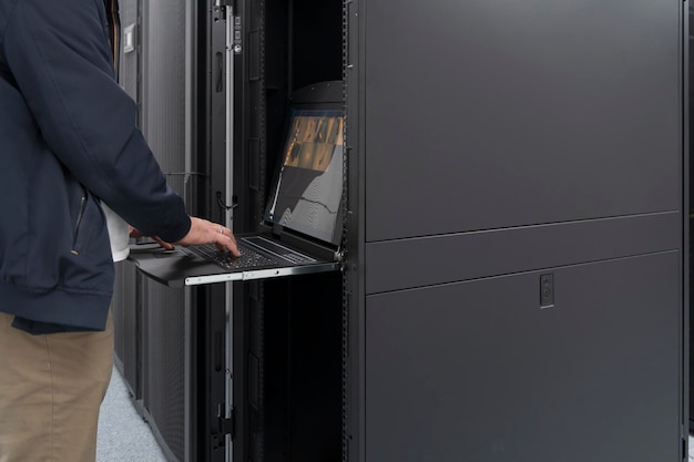 Close up on Data Center Engineer hands Using keyboard on a supercomputer Server Room Specialist Facility with Male System Administrator Working with Data Protection Network for Cyber Security