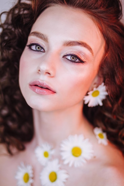 close-up portrait of beautiful young woman wearing flowers and make-up