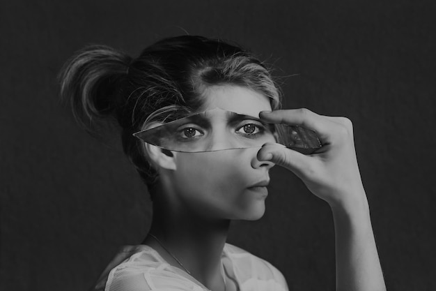 close-up portrait of young woman against black background