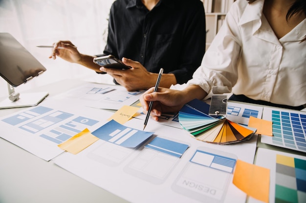 Close up ux developer and ui designer use augmented reality brainstorming about mobile app interface wireframe design on desk at modern officeCreative digital development agency