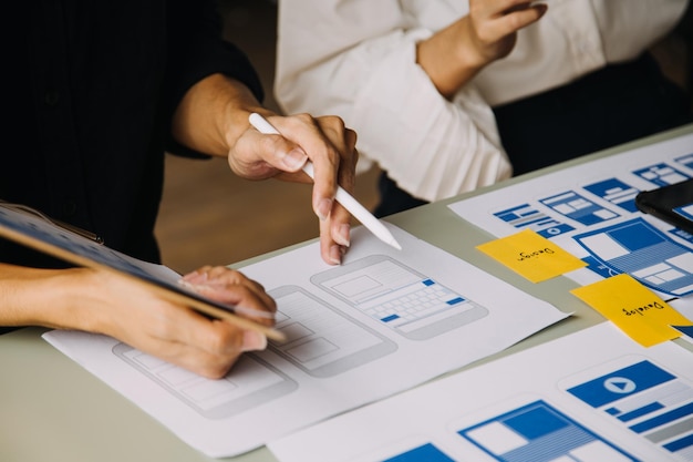 close up ux developer and ui designer use augmented reality brainstorming about mobile app interface wireframe design on desk at modern officecreative digital development agency