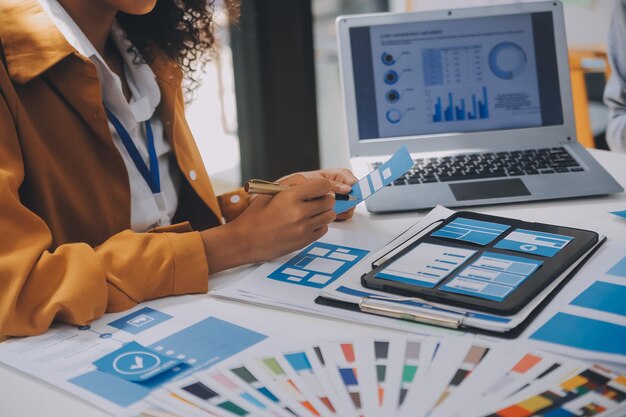 Close up ux developer and ui designer use augmented reality brainstorming about mobile app interface wireframe design on desk at modern officeCreative digital development agency