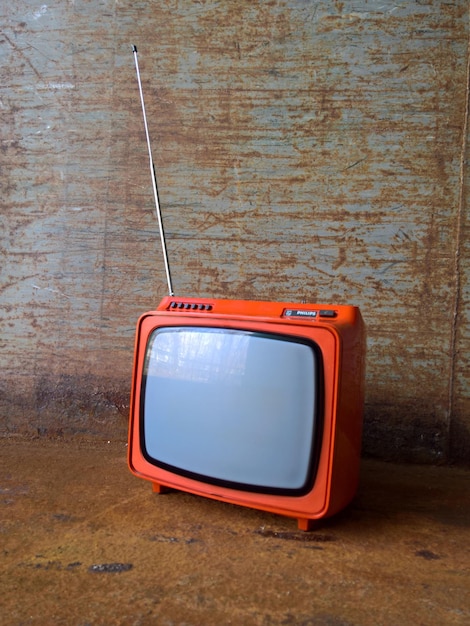 Close-up view of old-fashioned tv against wall