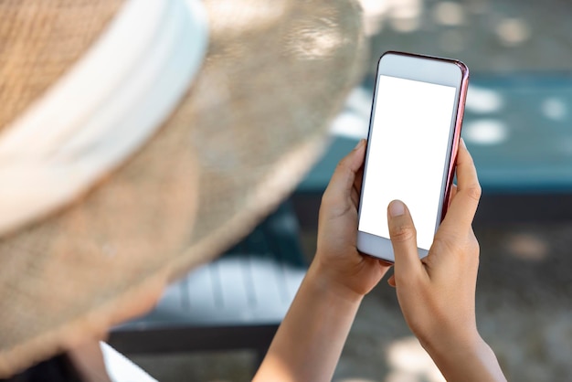 Closeup Asian woman hands holding and pointing on smartphone sunbathing by the sea Online shopping