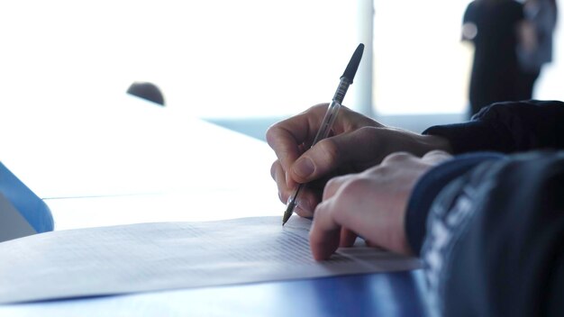Closeup of male hands with pen over document man signs the contract closeup