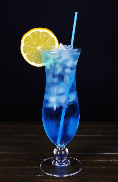Cocktailglass på bord på svart bakgrunn
