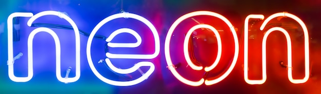 Colorful "neon" text written with neon lights on the wall