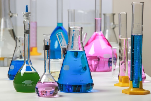 Composition of laboratory material with colored liquids in realistic glass pots chemical test for soy and corn.