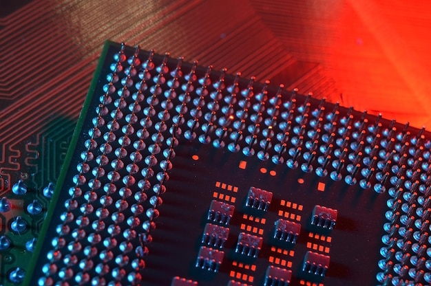computer cpu processor chip on circuit board motherboard background closeup with redblue lighting
