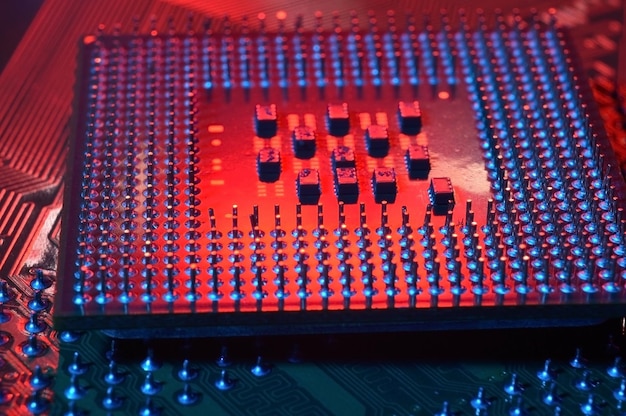 computer cpu processor chip on circuit board motherboard background closeup with redblue lighting